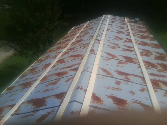 Rusted metal roof panels with new wood purlins before replacement in Point Of Rocks