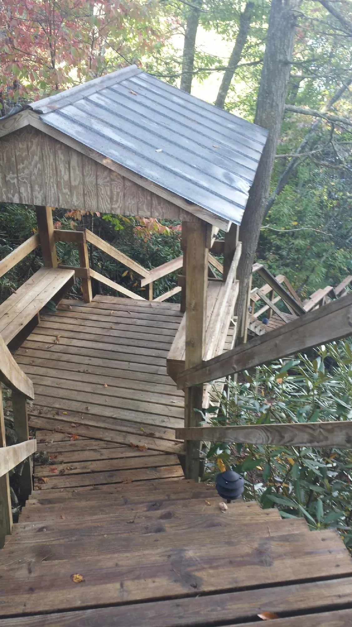 Metal roofed shelter over wooden steps on a wooded walkway — Skylight Repair & Installation work by our crew in Point Of Rocks