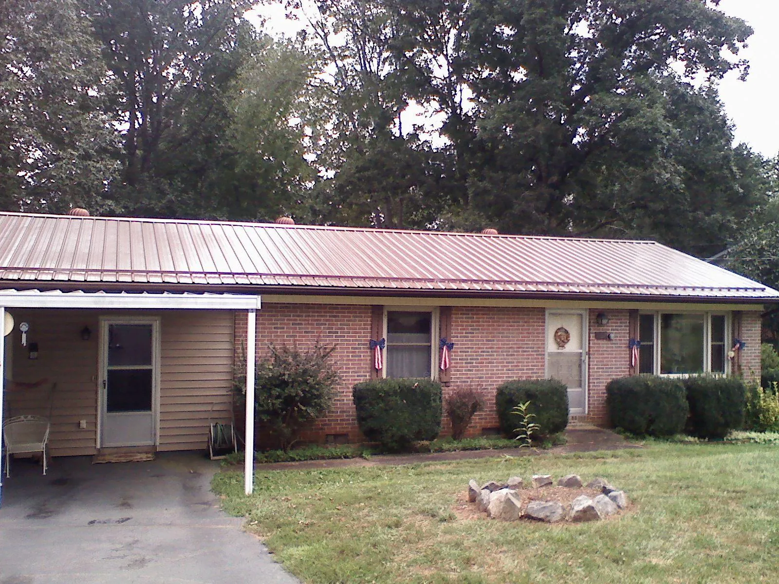 Bronze metal roof and carport on a brick ranch home — Roof Repair work by our crew in Point Of Rocks